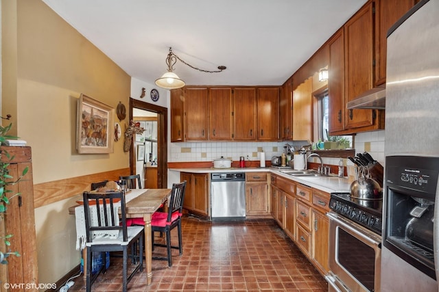 kitchen with decorative backsplash, appliances with stainless steel finishes, ventilation hood, and sink