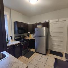 kitchen featuring light tile floors, black appliances, and sink