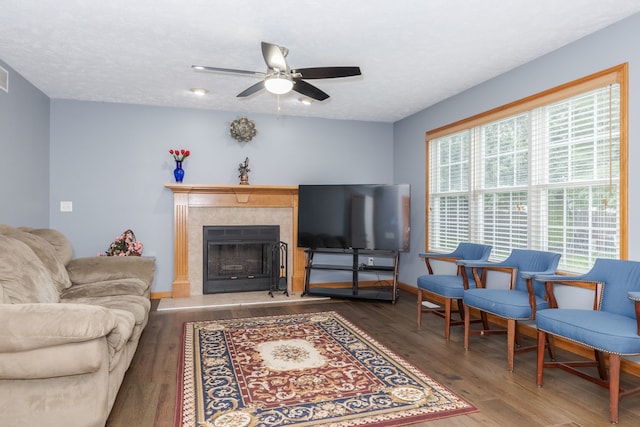 living room with ceiling fan, a textured ceiling, and dark hardwood / wood-style flooring