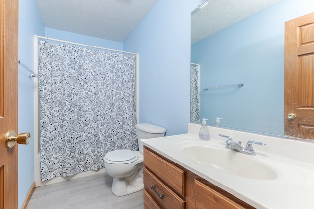 bathroom featuring tile floors, a textured ceiling, toilet, and vanity