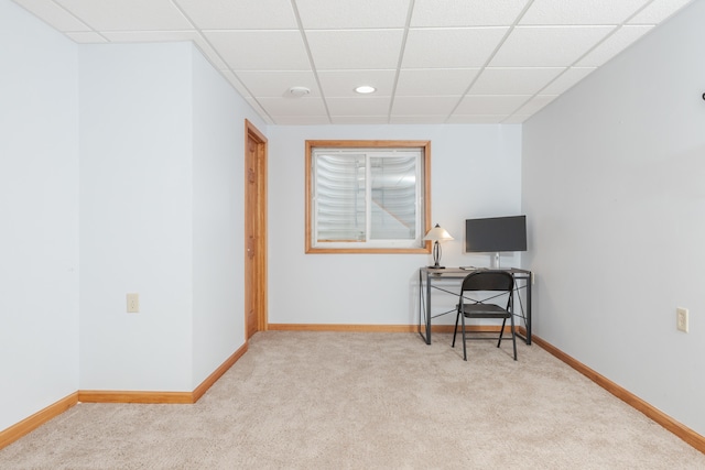 carpeted office space featuring a paneled ceiling