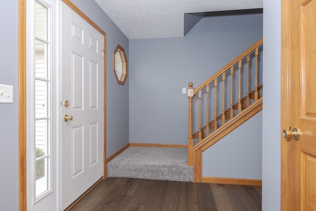 entrance foyer with a textured ceiling and dark hardwood / wood-style floors