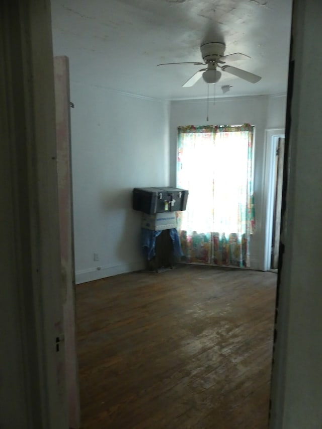 unfurnished living room with ornamental molding, dark hardwood / wood-style flooring, and ceiling fan