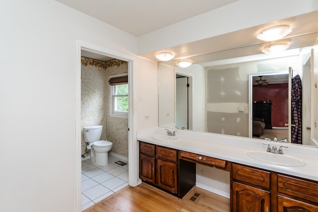 bathroom featuring wood-type flooring, vanity, and toilet