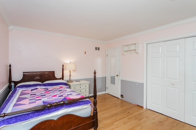 bedroom with a closet, ornamental molding, and light hardwood / wood-style flooring