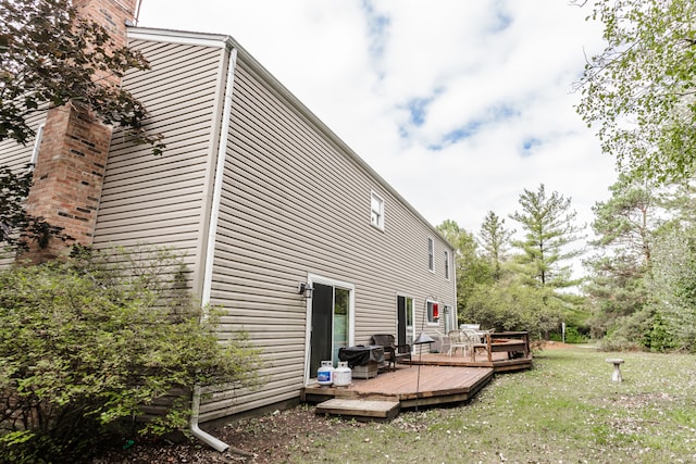 view of property exterior with a lawn and a deck