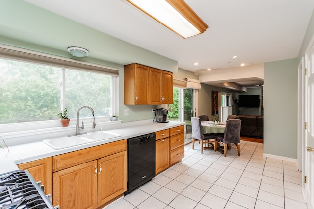 kitchen featuring a healthy amount of sunlight, dishwasher, light tile patterned floors, and sink