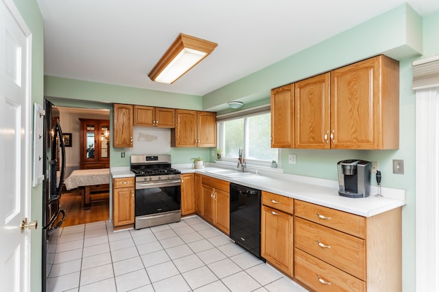 kitchen featuring light tile patterned flooring, gas range, sink, and black dishwasher