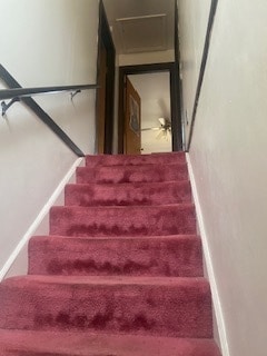 stairway with carpet floors and ceiling fan