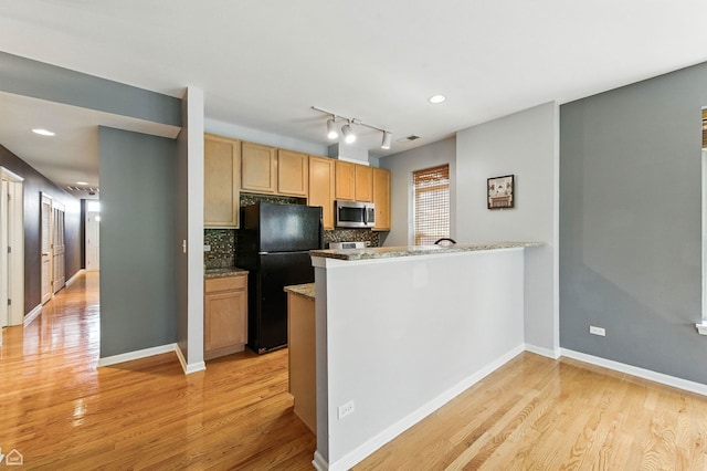 3811 S Langley Ave Unit 301, Chicago, IL 60653 - kitchen featuring freestanding refrigerator, stainless steel microwave, light wood finished floors, a peninsula, and decorative backsplash