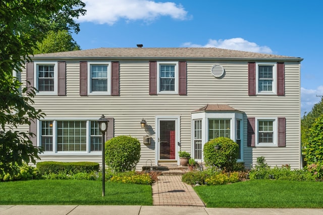 colonial home featuring a front lawn