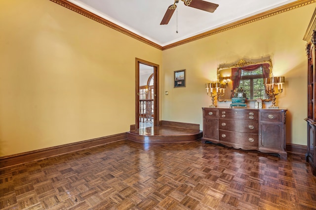 spare room featuring dark parquet floors, ceiling fan, and crown molding