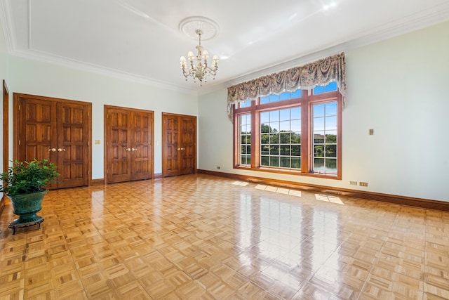 interior space featuring light parquet flooring, ornamental molding, and a notable chandelier