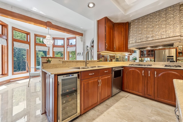 kitchen with sink, beverage cooler, kitchen peninsula, decorative light fixtures, and appliances with stainless steel finishes