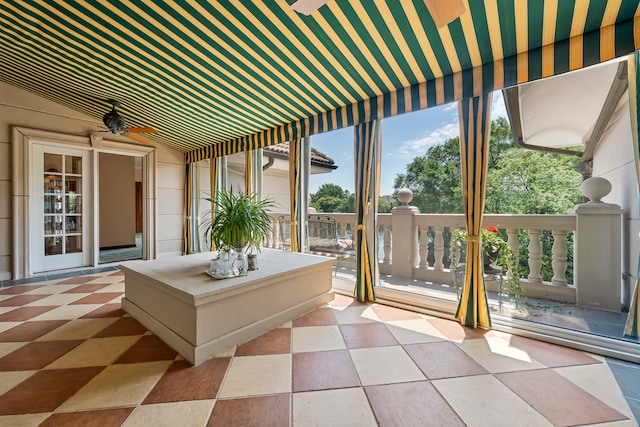 unfurnished sunroom featuring ceiling fan