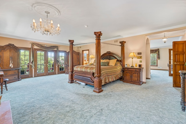 carpeted bedroom with a notable chandelier, ornamental molding, and french doors