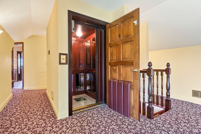 hall featuring carpet flooring and lofted ceiling