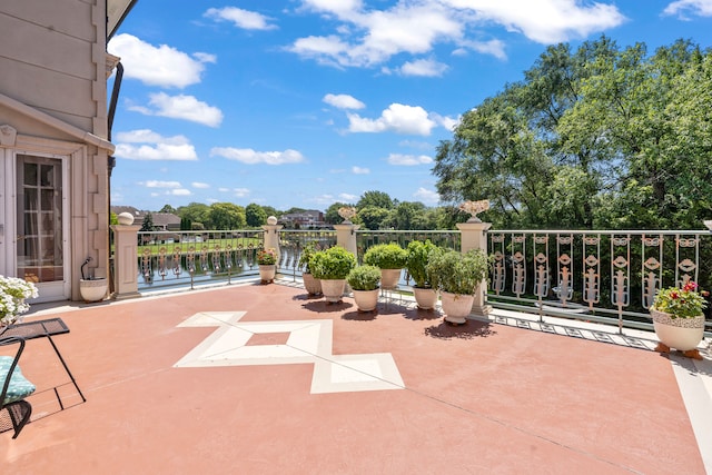 view of patio with a water view and a balcony