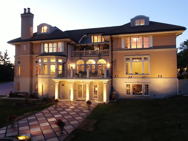 back house at dusk with a balcony