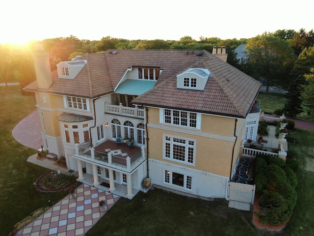 back house at dusk with a balcony