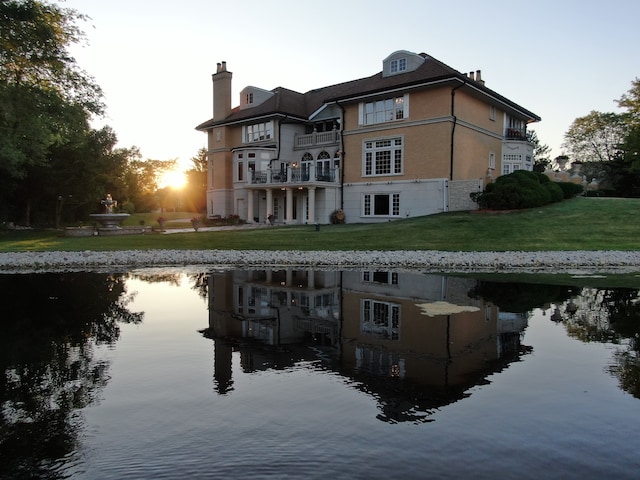 back house at dusk with a water view