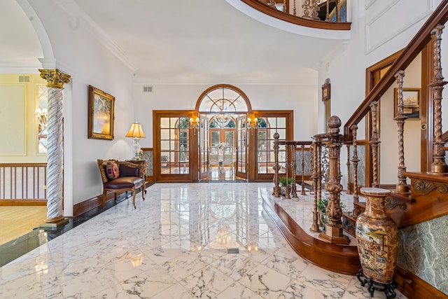 entrance foyer featuring crown molding and french doors