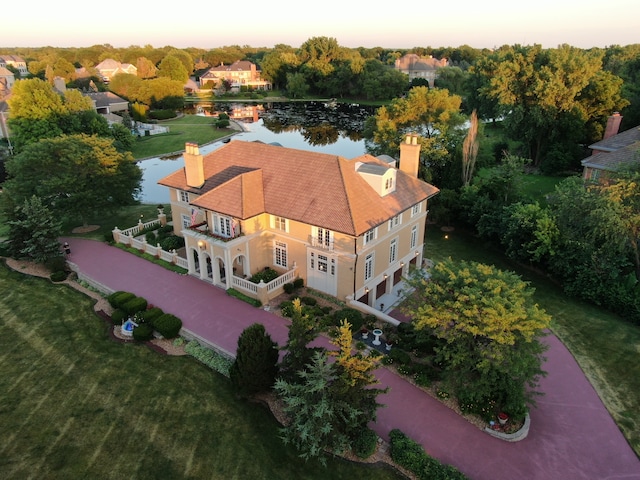 aerial view at dusk featuring a water view