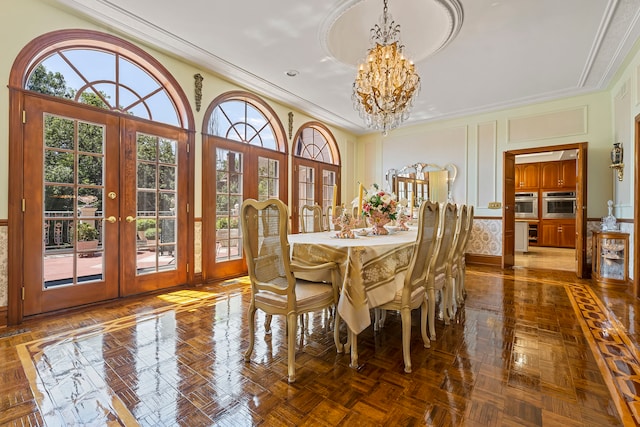 dining space with french doors, dark parquet floors, a healthy amount of sunlight, and a notable chandelier