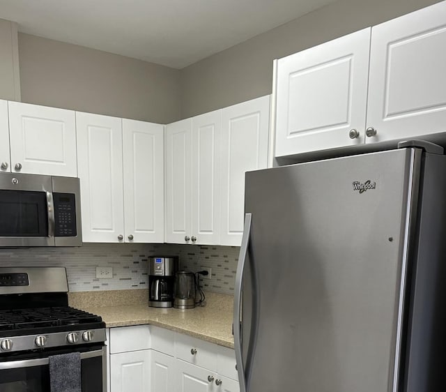 kitchen featuring white cabinetry, stainless steel appliances, and tasteful backsplash