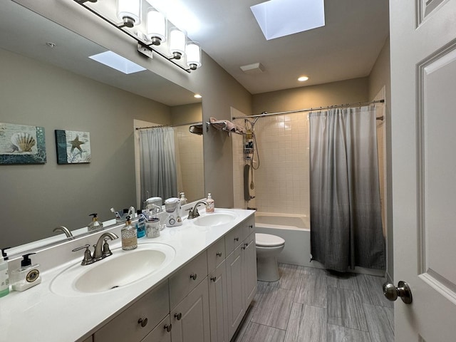 full bathroom with toilet, vanity, a skylight, and shower / bath combo with shower curtain