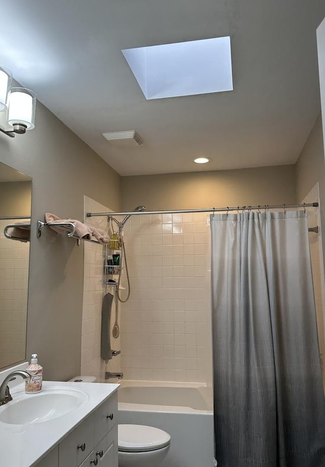 full bathroom featuring toilet, vanity, a skylight, and shower / bath combo