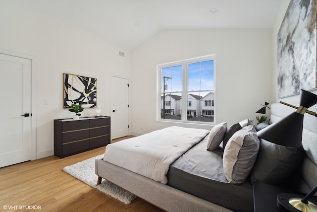 bedroom featuring lofted ceiling and light hardwood / wood-style flooring