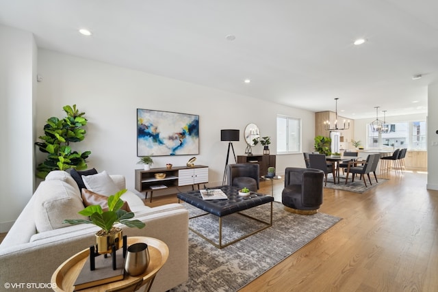 living room with an inviting chandelier and light wood-type flooring