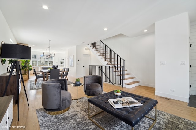 living room featuring an inviting chandelier and light wood-type flooring