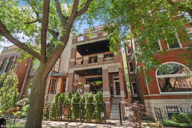 2732 N Seminary Ave Unit 3, Chicago, IL 60614 - view of front of property with brick siding, a balcony, a fenced front yard, and a gate