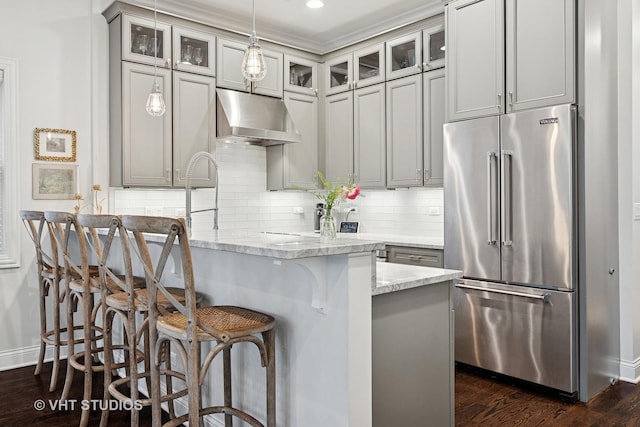 2732 N Seminary Ave Unit 3, Chicago, IL 60614 - kitchen featuring high end refrigerator, under cabinet range hood, dark wood-style floors, a kitchen breakfast bar, and pendant lighting