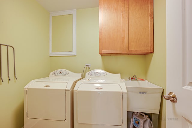 laundry area featuring cabinets, washer and dryer, and sink