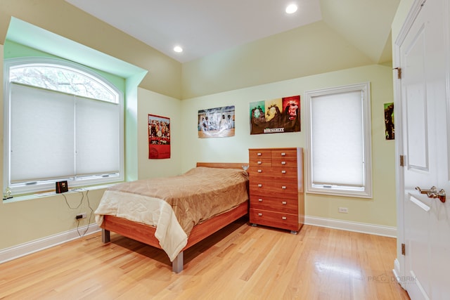 bedroom featuring lofted ceiling and light hardwood / wood-style floors