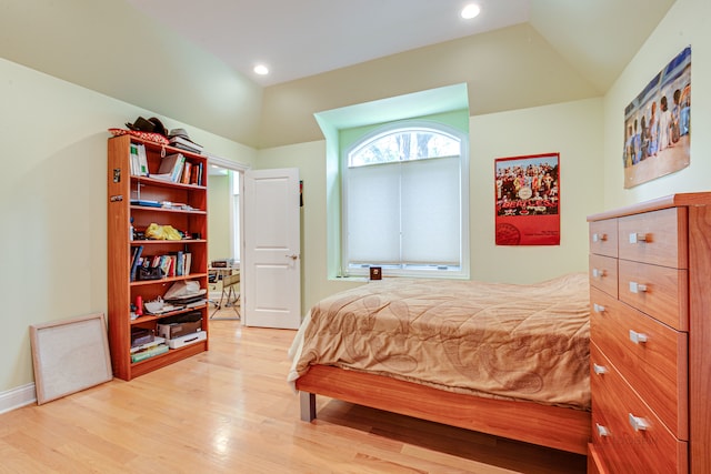 bedroom with lofted ceiling and light hardwood / wood-style floors