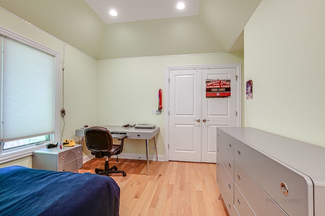 bedroom with a closet, light hardwood / wood-style flooring, and vaulted ceiling