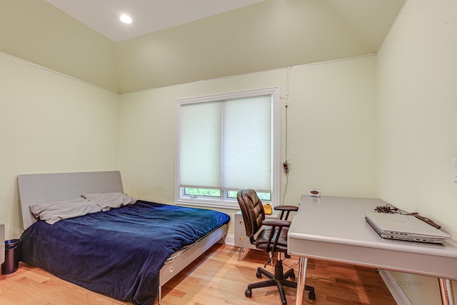 bedroom with lofted ceiling and light wood-type flooring