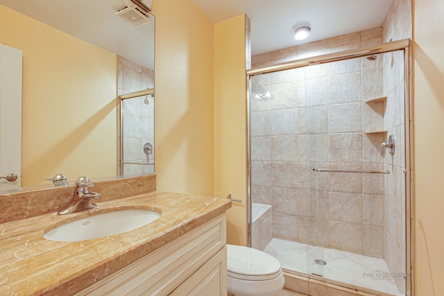 bathroom featuring toilet, vanity, and an enclosed shower