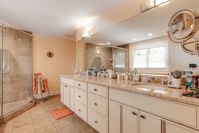 bathroom featuring tile floors, a shower with shower door, and double sink vanity