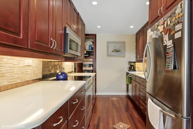 kitchen featuring appliances with stainless steel finishes, tasteful backsplash, and dark hardwood / wood-style flooring