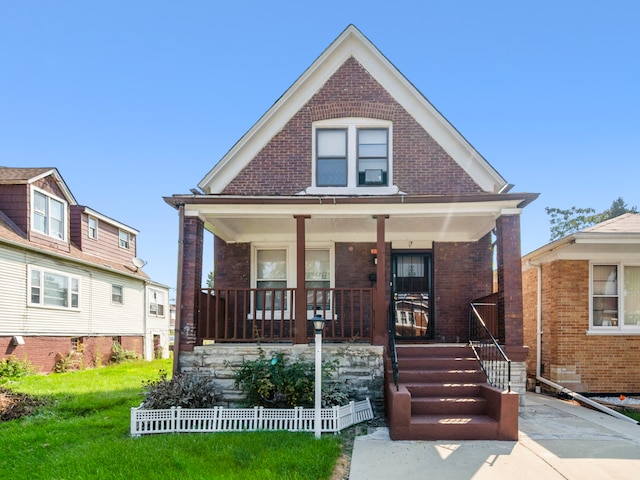 bungalow-style home with covered porch and a front yard