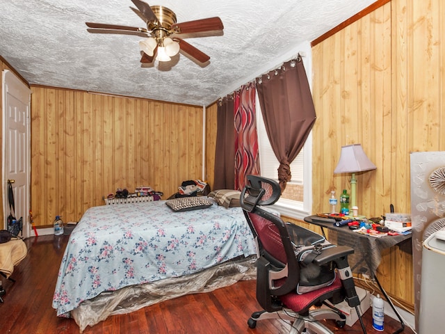 bedroom with wooden walls, a textured ceiling, ceiling fan, and dark hardwood / wood-style floors