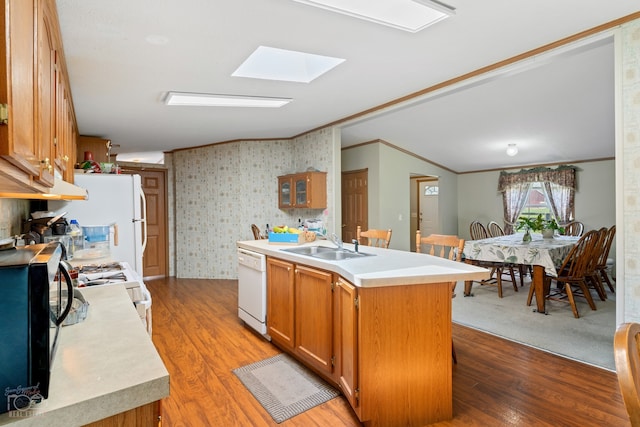 kitchen with light colored carpet, a skylight, ornamental molding, white appliances, and sink