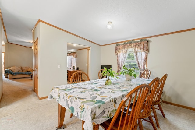 dining room featuring ornamental molding and light carpet