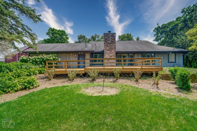 back of house with a wooden deck and a yard