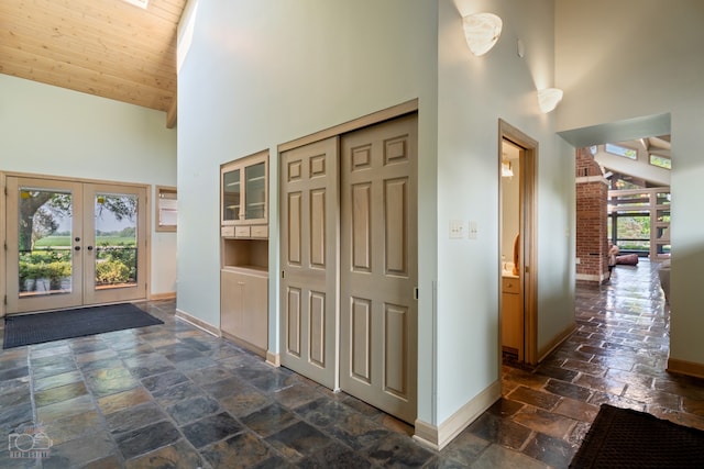 corridor featuring dark tile floors, high vaulted ceiling, and wood ceiling